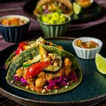 トマトベースで煮込んだラム肉と島らっきょ。パクチーソースのタコス