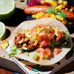 沖縄近海の魚介をミンチにしたタコミートに、チーズやトマトを盛り付けたスタンダードタコス