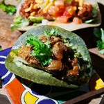 トマトベースで煮込んだラム肉と、島らっきょ＆パクチーソースのピリ辛タコス