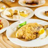 骨付きの豚肩ロースを使って、ウィンナーシュニッツェル風に仕上げた『骨付き豚肩ロースのカツレツ』。きめ細かな衣をまとわせて揚げ焼きにしたカツに、爽やかなレモンの酸味がベストマッチ。ワインとの相性も◎。