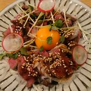 その日の和牛赤身肉をレアに焼いて特製ピリ辛ダレと卵黄を混ぜてどうぞ。