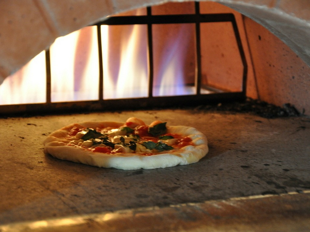 生地から手作り石窯で焼き上げる当店自慢の窯焼きピザは絶品