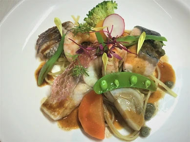 沖縄県産の白身魚や甲殻類をふんだんに使う『本日のおすすめ魚介類のにんにくバター焼き』