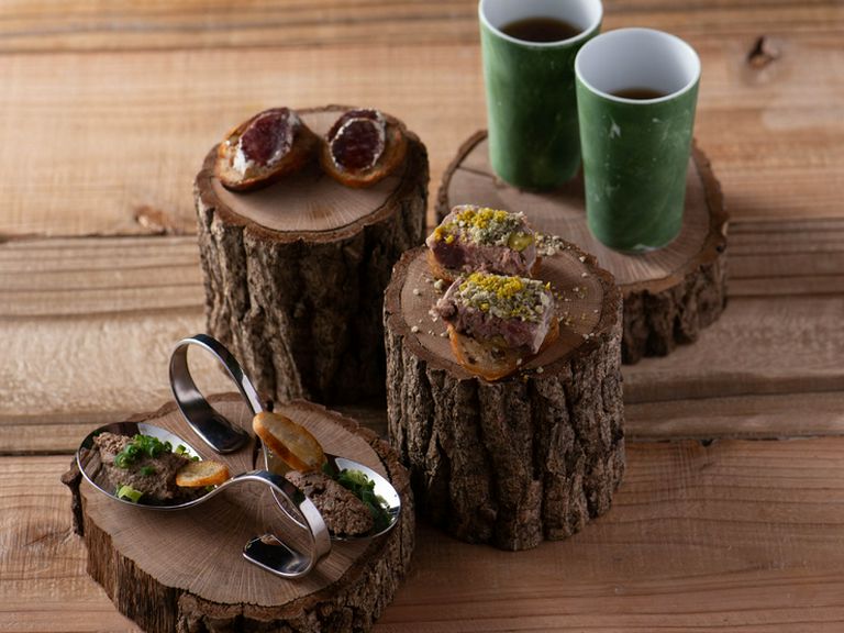 山小屋でのキャンプをイメージ。切り株に盛り付けられた前菜『熊本　インビテーション』