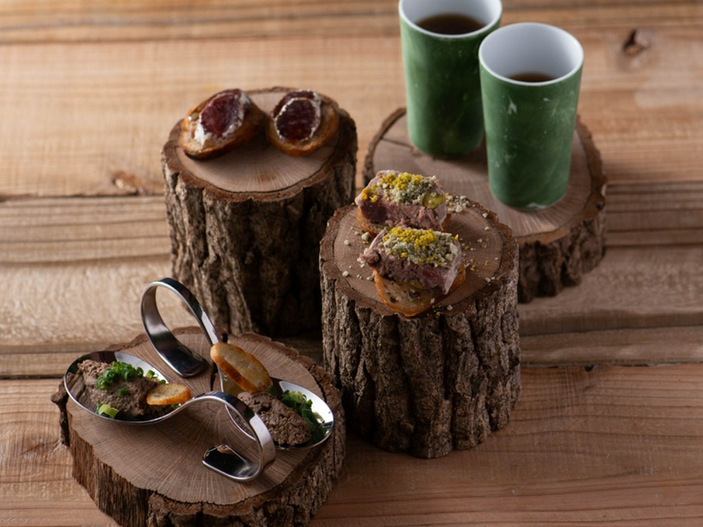 山小屋でのキャンプをイメージ。切り株に盛り付けられた前菜『熊本　インビテーション』