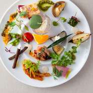 昼・夜の全コースは、「湖鏡にようこそ！」の思いを込めた、このスペシャリテから開幕。旬野菜を中心に20種以上の素材を用い、季節の彩りと滋味に満ちる10品以上を盛り合わせ。ひと口ごとに笑顔が増す美味しさです。