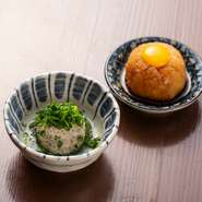 お通しとは思えない完成度の高さが自慢。やんばる地鶏に椎茸、玉ねぎ、柚子胡椒を加え鳥だしで煮たぴりっとした味わいのつくね煮と、大根おろしに自家製ダレ、うずらの玉子をのせたさっぱりとした食感のお口直し。