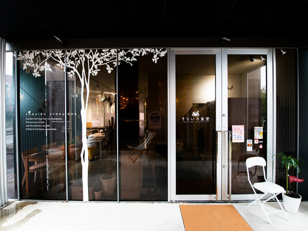 樹木のシルエットをあしらった全面ガラスばりの明るい店構え