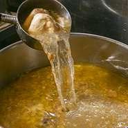 牛骨で取ったスープの特徴は、さっぱりとした口当たりの中に残る鮮やかなコクです。牛の骨と薬膳を4～5時間煮込んで作ったもの。『世界一辛い』と称される重慶火鍋ですが、辛いだけではなく味の奥深さの秘密を◎