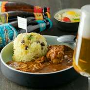 淡路島から届く新鮮玉ねぎにトマト、エリンギ、マッシュルームなどの具材の水分だけで2日煮込んだ無水カレー。たっぷり染み出た野菜の甘さに約20種のスパイスが加わり絶妙なおいしさ。季節のターメリックライスと。