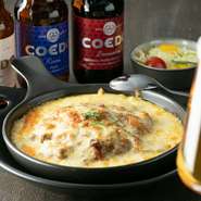 『無水手羽元カレー』にモッツァレラチーズをたっぷりとのせ、オーブンで焼いています。チーズのコクがカレーの辛さをマイルドにし、ビールや赤ワインにも合う一品です。