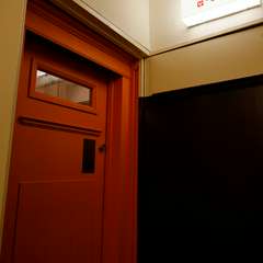 温かみのある緋色の扉から入店。ビル4階にある隠れ家
