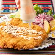 人気メニュー『ミラネッサ・デ・ポジョ』は、大きな鶏胸肉のカツレツ。南米全土で食べられている人気料理です。鶏肉を薄く引き伸ばし、カラッと揚げてあるので、さっぱりと食べやすいのが特徴です。