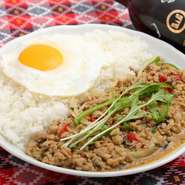 鶏ひき肉と数種類の野菜を炒めたタイ料理の定番ごはんです。目玉焼きの黄色、ピーマンの赤が目に鮮やかで、スパイスの香りが食欲をそそる一品。好みに合わせて辛さの調節が可能です。
