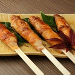 一本一本手作りで作ってます。米を炊き、調味料をまぜ、串につけ、米沢豚のお肉を巻いてます！　そんな肉巻きたんぽを、炭火で焼き、自家製の仙台味噌を二度漬けで提供しております。