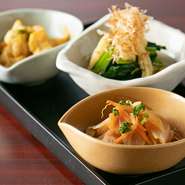 『トマト土佐煮』や『豆腐の信田巻き』など、厳選された食材と料理人自慢の和食技法で仕上げるおばんざいの盛り合わせ。日替わりのお浸しや南蛮漬けを含むラインナップから、お好みの3品を選べます。
