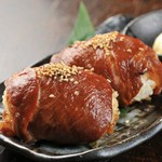 黒豚の肩ロースをタレに漬け込み、おにぎりを包みオーブンで焼き上げた一品！　老若男女問わず人気を集めています！