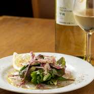 写真は『佐賀県産真鯛のカルパッチョ』。旬の鮮魚が主役の『本日のカルパッチョ』。塩やオリーブオイル・レモン汁。魚の種類によってはバルサミコソースなど、魚に合わせたテイストで楽しませてくれます。