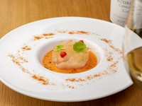 春から初夏の前菜の例。レモングラスでマリネしたホタテ・白ミル貝・甘エビを、湯煎で繊細な火入れを施してタルタルに。パプリカとクミンのソースがアクセントになり、トマトのジュレとミントで季節の香りをプラス。