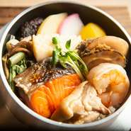 蓋を開けた瞬間、おいしい匂いをいっぱいに含んだ蒸気が一気に立ち上ります。海鮮・肉類・高級食材など、メニューは全部で12種類。
※画像は一例。五目釜めしとなります。