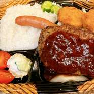 安定人気の大きなハンバーグを使ったおべんとうです。
ジューシーな長ーいソーセージと一口カツもついて
ボリューム満点な弁当！