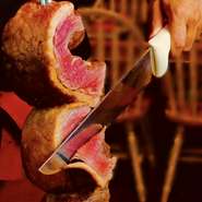 赤身の旨みを堪能できる希少なイチボ肉は一番人気メニュー。串刺しにした肉のブロックを専用のシュラスコマシーンで香ばしく焼き上げ、目の前でスライスして提供。シンプルな塩味で、ジューシーな肉汁がたまらない！