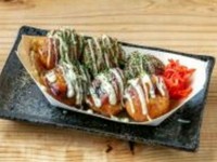 揚げたこ焼きは、サクサクの食感が特徴で、中にはふんわりとしたお好み焼きの具が詰まっています。この美味しいおやつは、特製のソースとクリーミーなマヨネーズが絶妙なバランスで絡み合います。