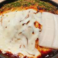 広島風お好み焼き「豚もちチーズ焼」は、もちもちの生地に豚肉、とろけるチーズ、麺そして新たにもちもちの餅を絶妙に組み合わせた贅沢な一品です。特製のソースとマヨネーズが絶妙で、甘辛くてコクのある味わい。