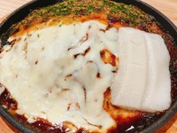 広島風お好み焼き「豚もちチーズ焼」は、もちもちの生地に豚肉、とろけるチーズ、麺そして新たにもちもちの餅を絶妙に組み合わせた贅沢な一品です。特製のソースとマヨネーズが絶妙で、甘辛くてコクのある味わい。