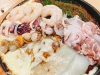 「スペシャル焼」は、もちもちの生地に豚肉と麺、新鮮な海鮮、もちもちの餅、そしてとろけるチーズが絶妙に組み合わさった逸品です。特製のソースとマヨネーズが、豚肉、海鮮、餅、チーズの絶妙な味わいが特徴です