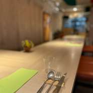 このカウンター席から店づくりは始まりました。広めの椅子でゆったりと、ワインと料理、会話を味わう贅沢な時間をどうぞ。