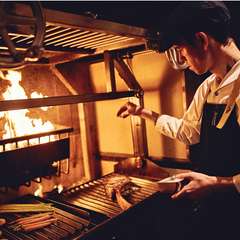 最新のウッドファイヤーグリルで焼き上げる、本格的な肉料理
