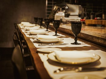 カウンターの目の前で、シェフと気さくに話しながら食事を				
