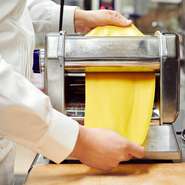 名物のトルテッロに使われているパスタは、毎日手打ちで作られているフレッシュパスタ。水は一切使わず、ら卵黄だけで練り上げた濃厚な生地をパスタマシーンで均一に伸ばし、カットして具を包む。				