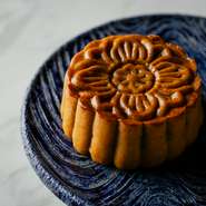 通常、月餅の餡といえば蓮の実の餡がおなじみだが、平賀シェフ手作りの月餅は、中に小豆あんと飴だきの胡桃入り。9月の（陰暦8月15日）中秋説の時期には、中に鹹蛋（塩卵）の黄身が入る。要予約。