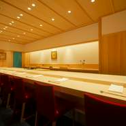 樹齢250年近い吉野檜の一枚板のカウンターが印象的な店内は、背筋がのびるほどよい緊張感があります。厨房を仕切るのれんは、“新橋色”という鮮やかなターコイズブルー。佐竹ワールドを堪能する舞台です。				
