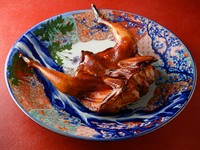 豪快に丸ごと焼いて切り分ける『香鶏のパリパリ焼き 麻辣風味』
