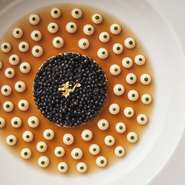 ロブション氏のシグネチャーとも言える皿。甲殻類の柔らかいジュレを敷き詰め、カリフラワーのクリームとパセリのピュレでドットを描く。中央にはセルクルを使い丸く盛り付けた蟹のサラダ、その上にキャビアを飾る。