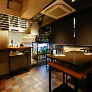 壁にメニューが貼られ、酒がずらりと並ぶ「角打ち」側のスペースは、気軽に飲めるカジュアルさ。鮮やかな布で包んだ日本酒をオブジェに使いと、オシャレさもプラスされた、女性ひとりでも入りやすい空間です。