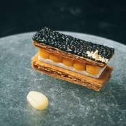 原点となったお菓子づくりと、料理人でもある自身を重ねた逸品。フィユタージュにエシャロットのムースを重ね、生とピクルスのホオズキを交互に並べます。ブラックダイヤモンドをイメージしたキャビアの層を重ねて。