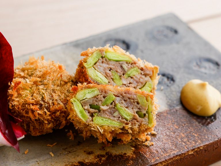 シャポンを加えたパテ・ド・カンパーニュをつなぎに使った旬の空豆入りのメンチカツ風の一皿。