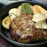 ふんわりとジュウシーなハンバーグを焼き野菜といっしょに鉄板にのせました。