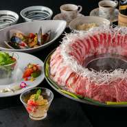 九州の素材を堪能できる鍋コース。『博多炊き肉鍋』は厳選した九州産黒毛和牛や耳納あか豚、沖縄あぐー豚などの肉と細切りの白ネギを牛テールスープで炊き上げます。テールの塩ダレ、トマトダレの2種のつけダレで。