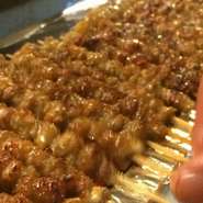 焼いては寝かせを繰り返し提供される福岡名物のグルグル巻きの皮串。タレ、塩、道東特有のさとうもあり！