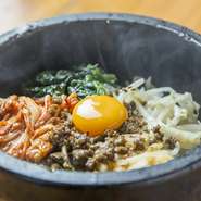 ごま油とコチジャンで味付けした牛ひき肉、ナムル、キムチ、卵をご飯といっしょによくかき混ぜて食べます。