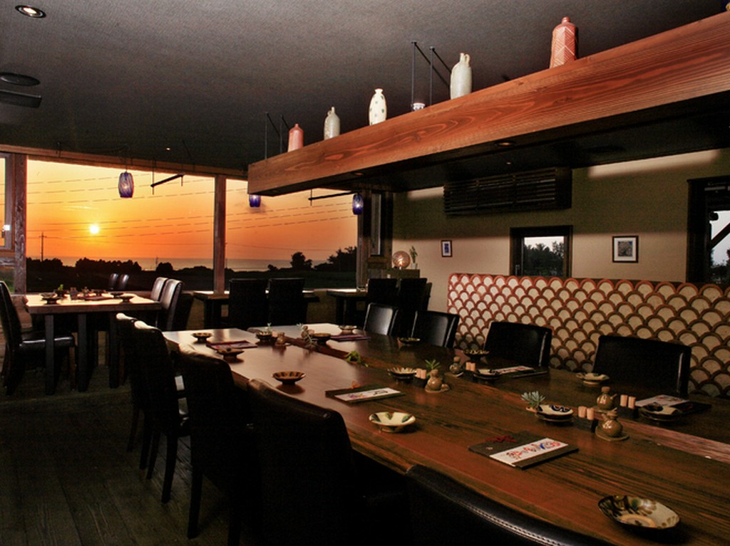 窓の外には、夕日とサトウキビ畑が沖縄時間を演出