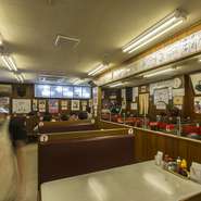 昔のアメリカンダイナーを思わせるボックスシートや、雰囲気満点のメニュー表。これらは前の店から移転する際に、元々の姿で持ってきた物。常連さんから「元の店のままで」と、お願いされたのがきっかけです。