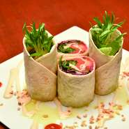 スモークサーモンと野菜をタコスシートで巻きました。チェダーチーズソースとベトナム産ホットチリソースで味付けしております。