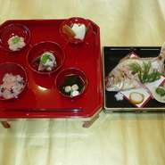 赤ちゃんに始めて御飯を食べさせる行事で、お膳の上に赤飯、鯛の焼き物、煮物、香の物、清まし汁を添えます

