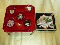 赤ちゃんに始めて御飯を食べさせる行事で、お膳の上に赤飯、鯛の焼き物、煮物、香の物、清まし汁を添えます

